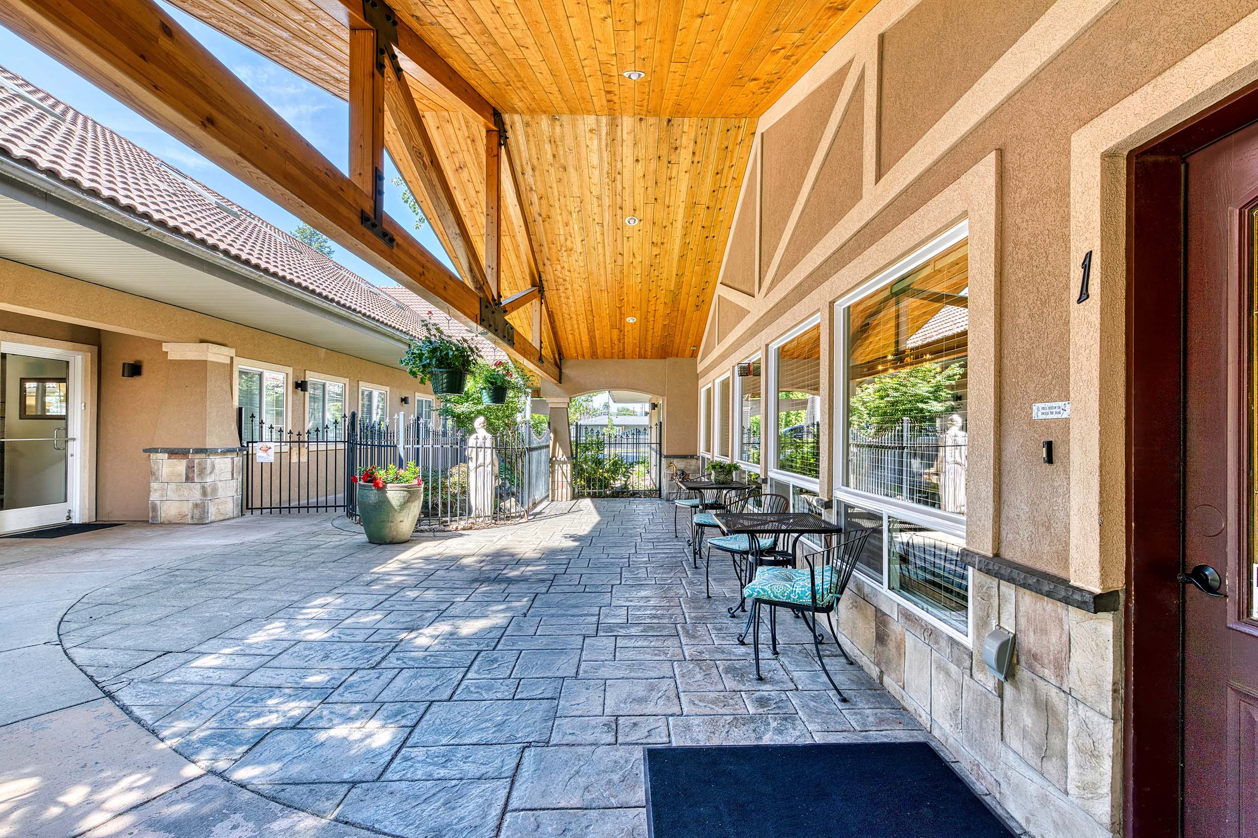 entrance to community with patio seating and greenery