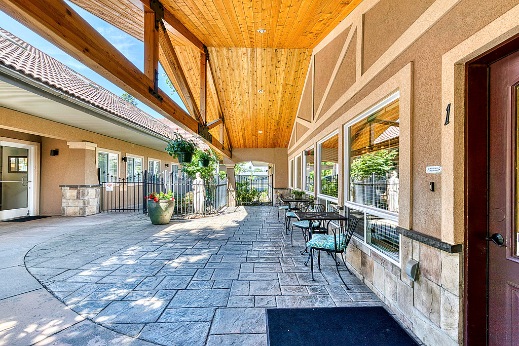 entrance to community with patio seating and greenery